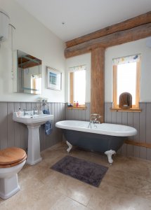 Traditional bathroom with clawfoot bath and exposed beams