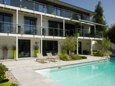 Baufritz turnkey home- Exterior shot with swimming pool and balconies