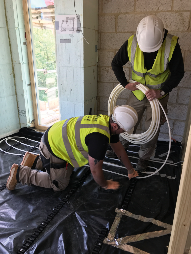 Men install underfloor heating