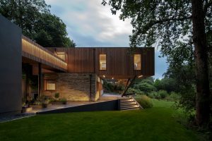 Timber clad house on stilts with wrap-around patio