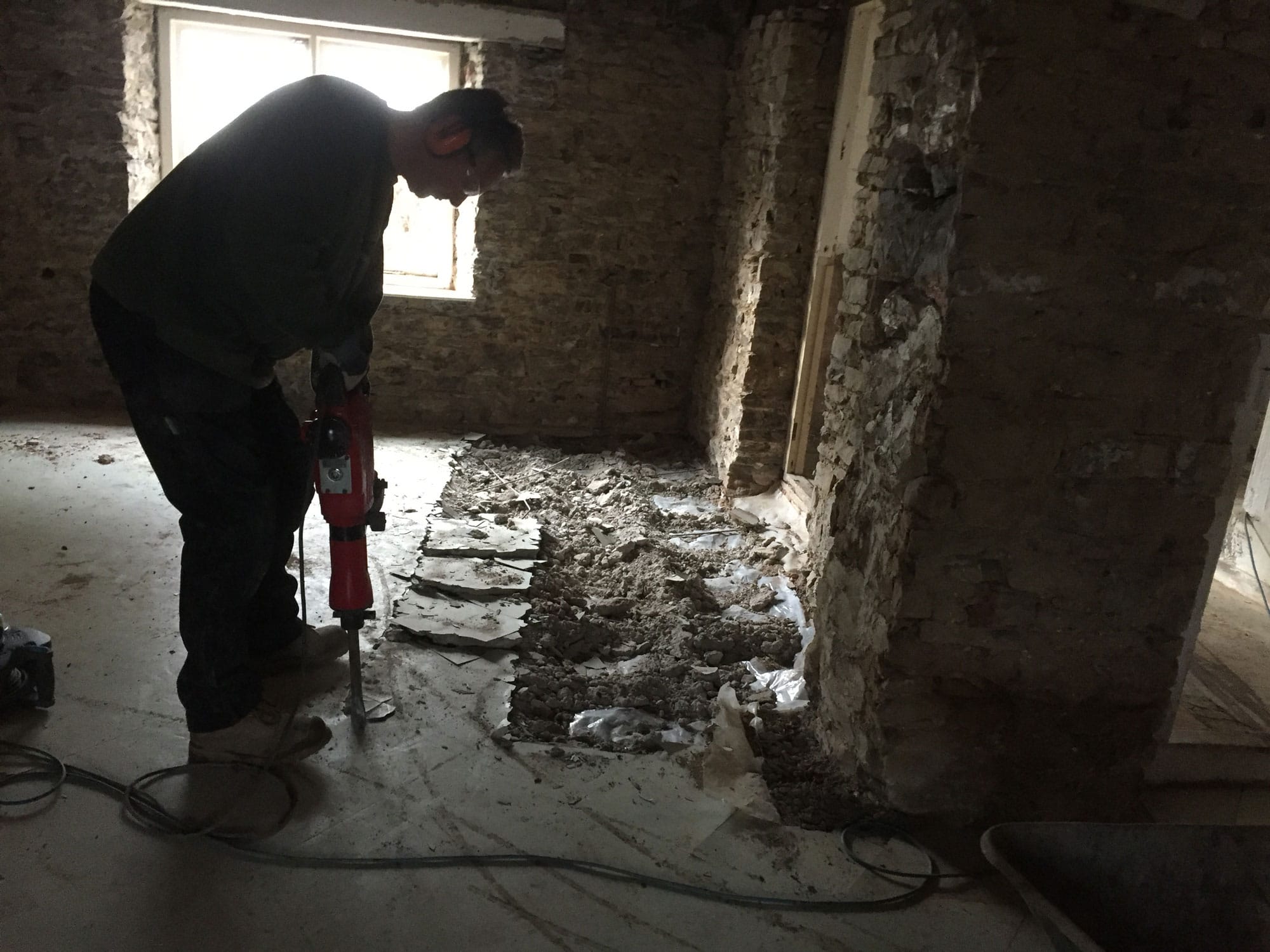 Man breaking up the floor in a period renovation