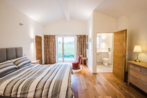 Bedroom with wooden floorboards and en suite