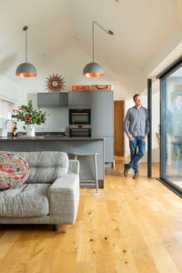 Man stands in open-plan kitchen