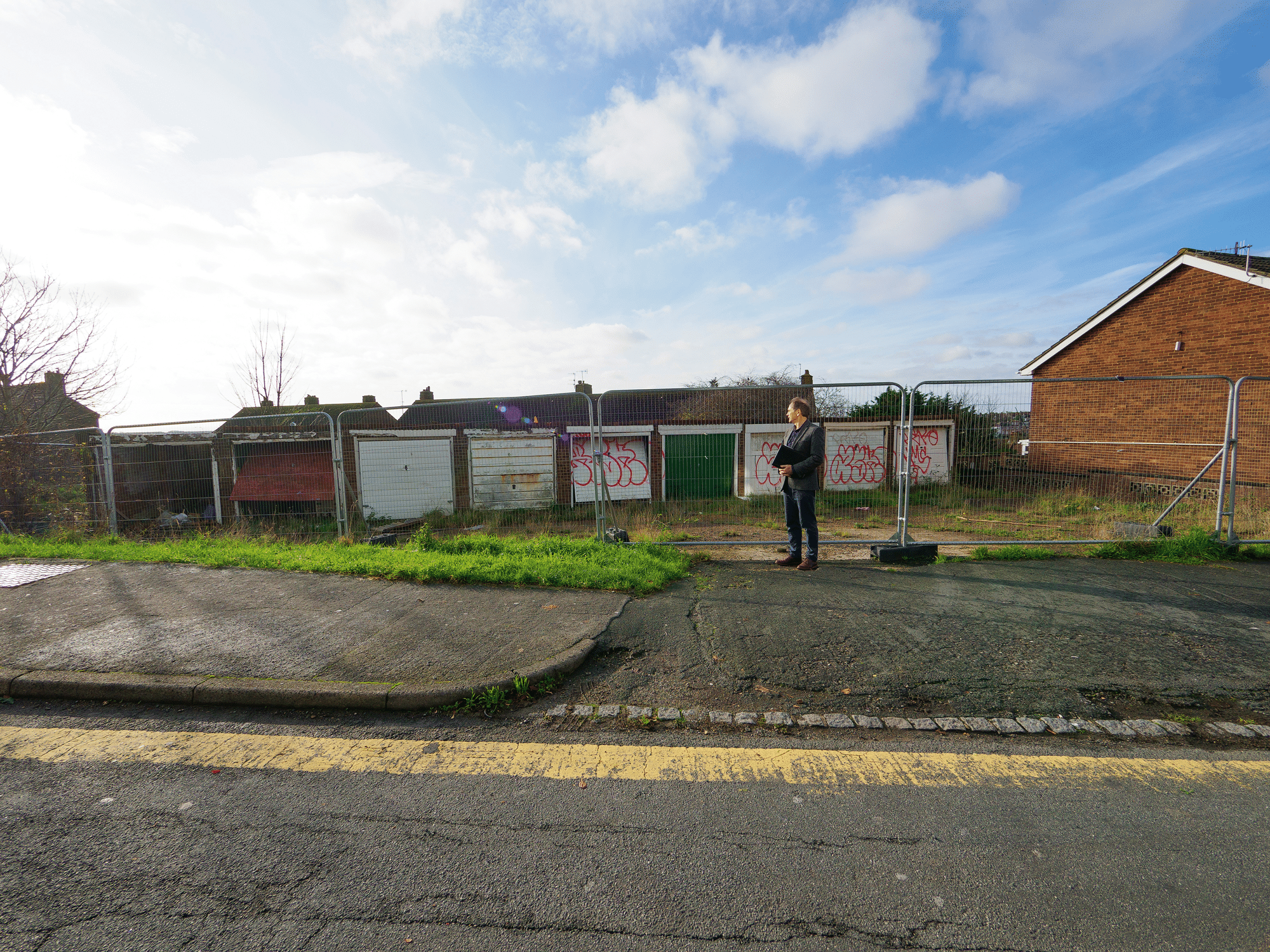 Person surveys derelict garage plot