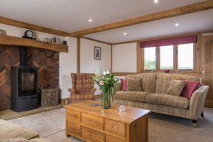 Sitting room with exposed beams and a fireplace