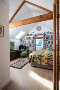 Bedroom with bookshelf and exposed beams