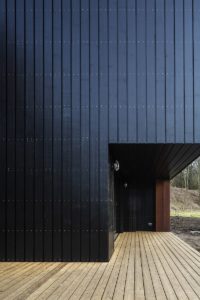 Black clad house with wooden decking