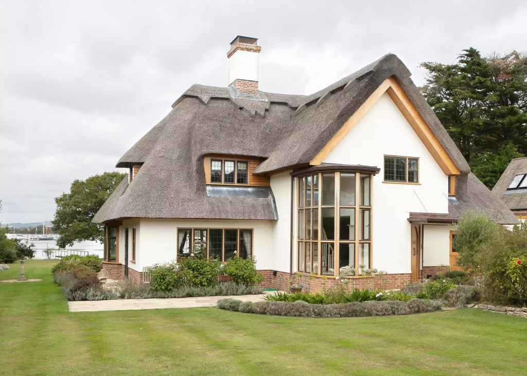 period home renovation with thatched roof and white render exterior