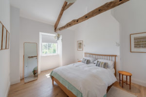 White bedroom with exposed beam