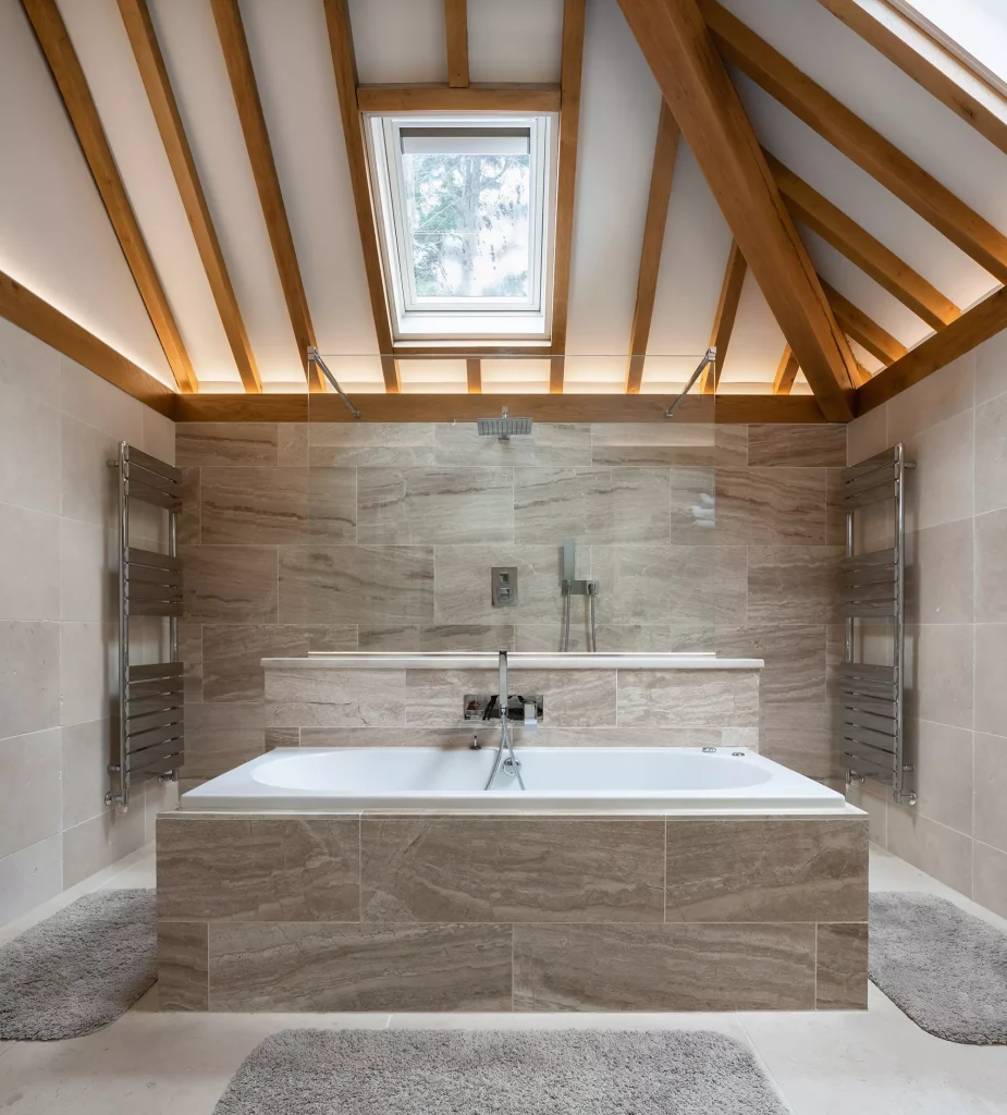 Steve and Janine Carney's oak frame annexe ensuite bathroom with stone tiles, exposed beam ceiling and walk in shower