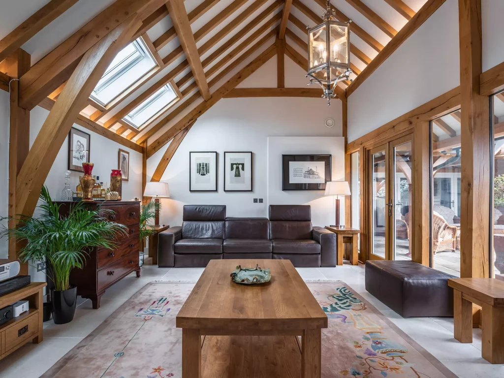 Steve and Janine Carney's oak frame annexe main living room with exposed beam structures looking out to the sheltered balcony 