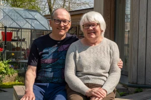 Julie and John posing outside their remodeled home