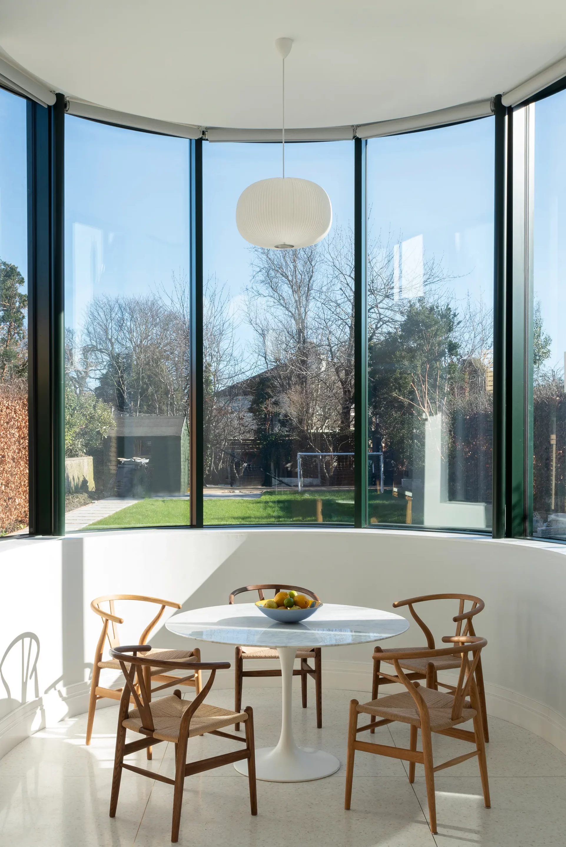 Dining area inside curved glass conservatory