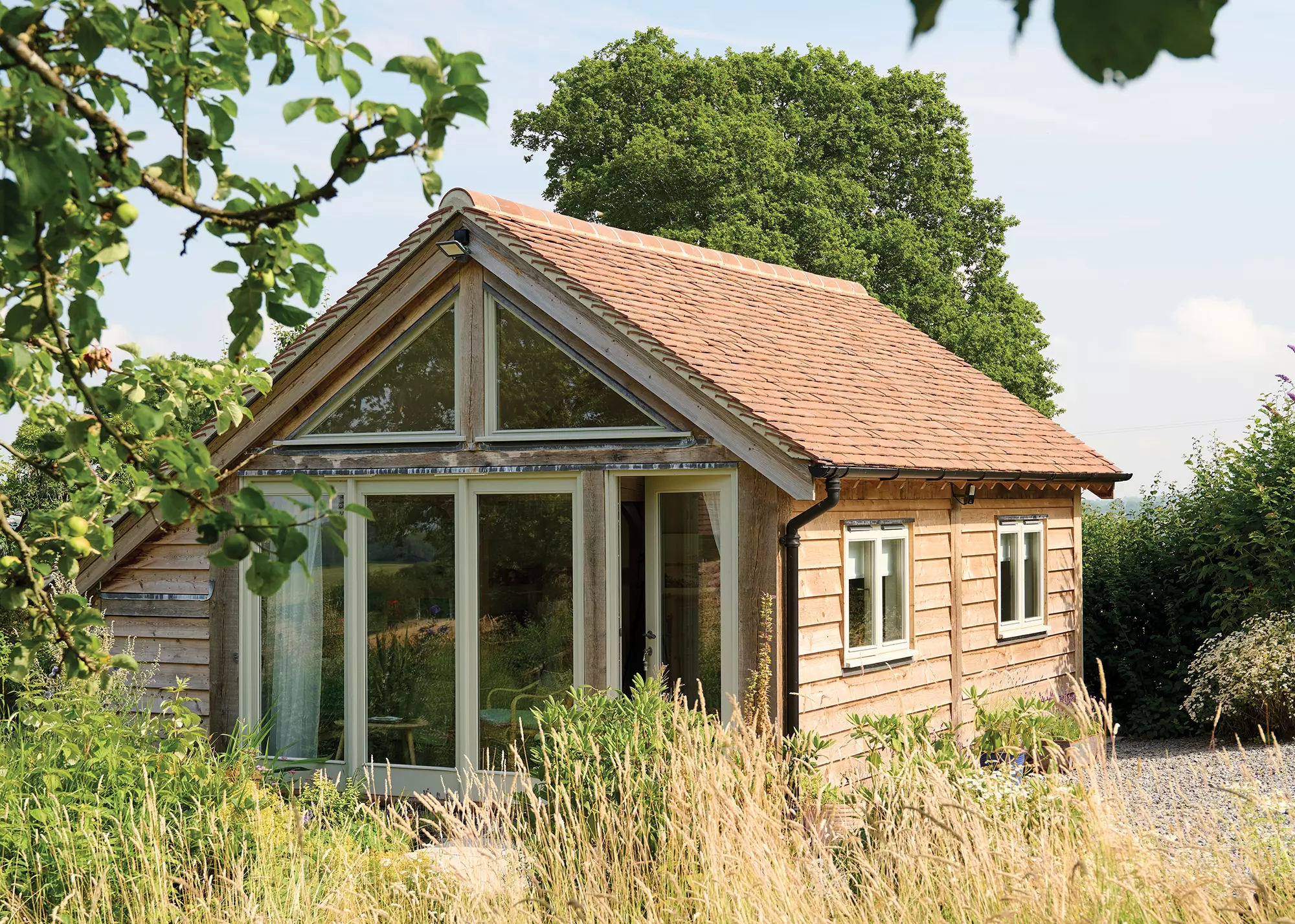 oak frame outbuilding with clay roof tiles and large glazing by Border Oak 