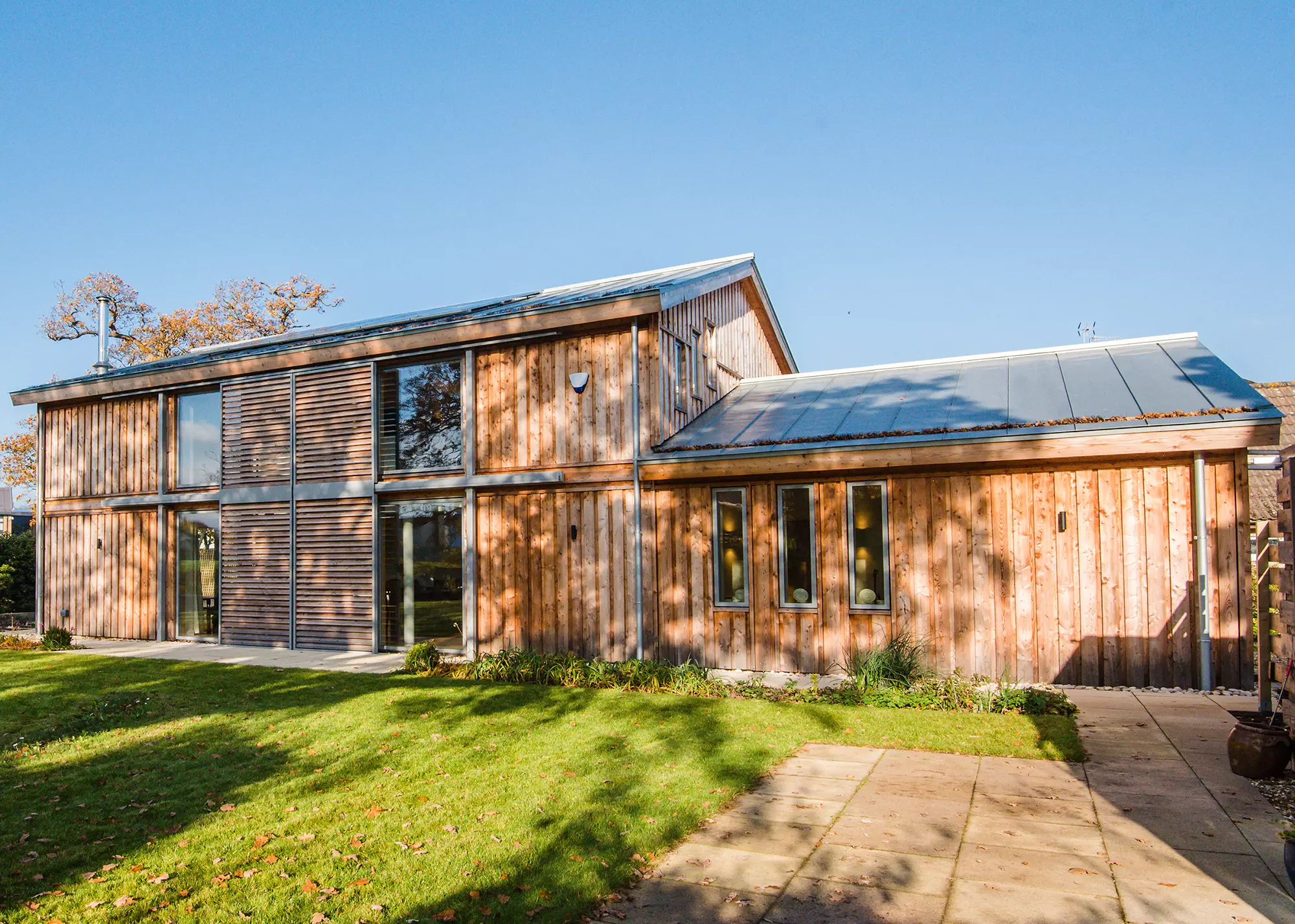 Cladded home with movable louvred shutters to design out overheating