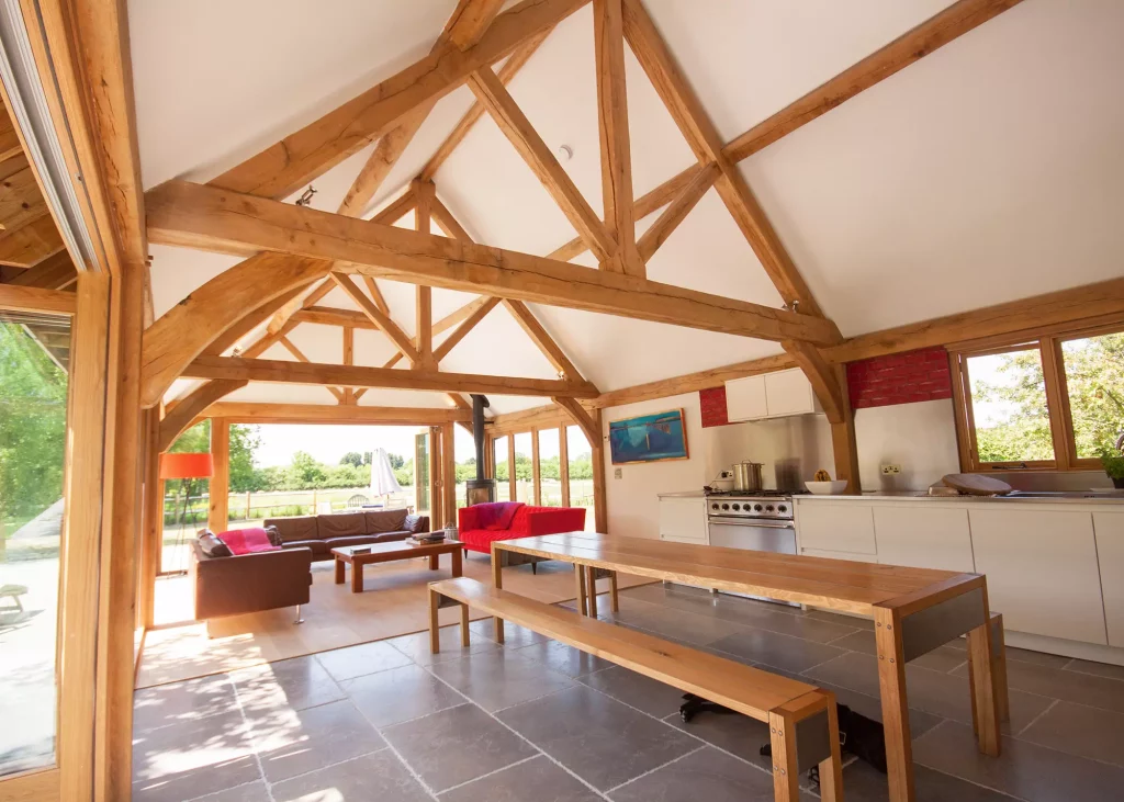 kitchen-living-dining area with exposed oak frame and large glazed doors out onto the garden