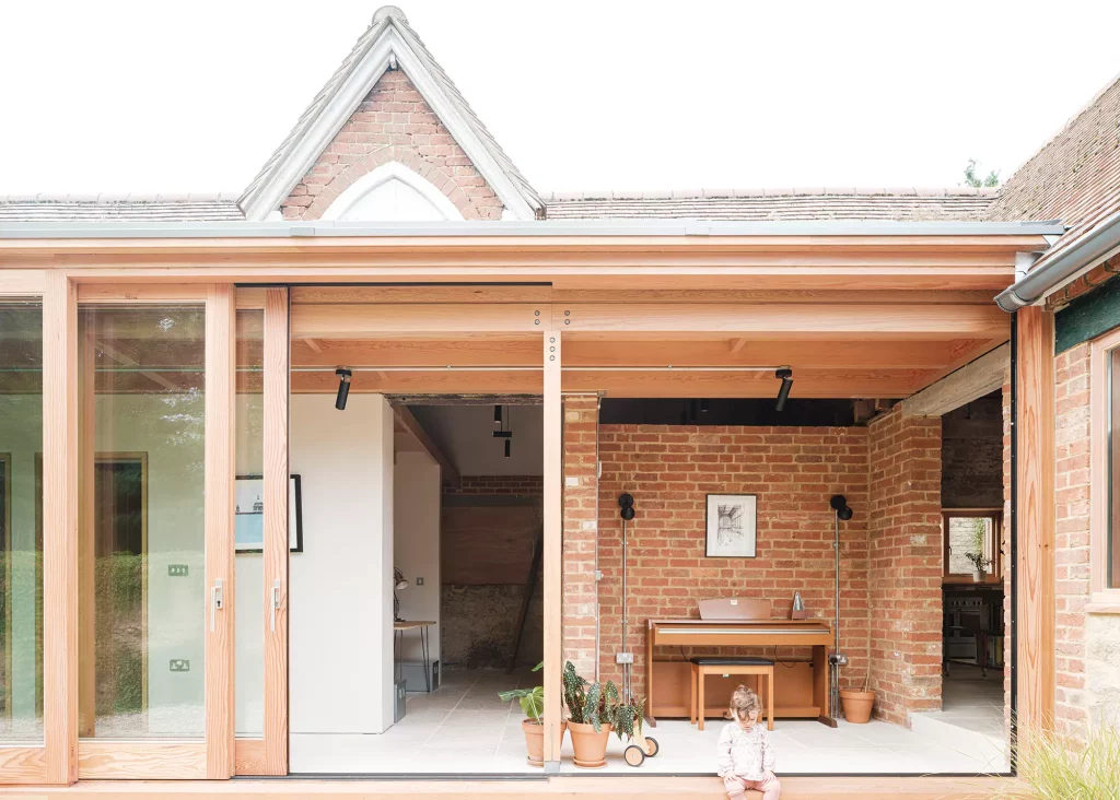 Open plan stable renovation with full-height sliding doors and brick detailing