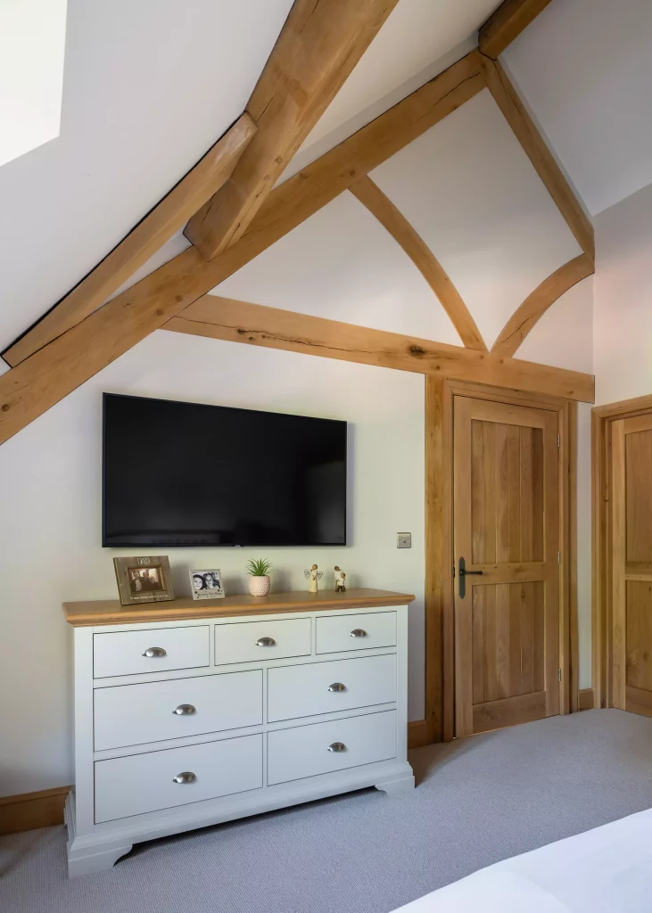 bedroom wall supported with curved oak frame trusses