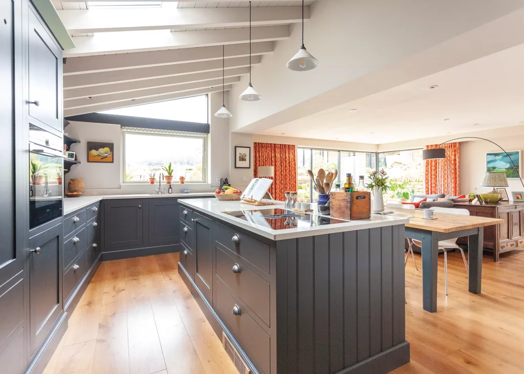 Shaker-style kitchen with exposed beams and pendant lamps 