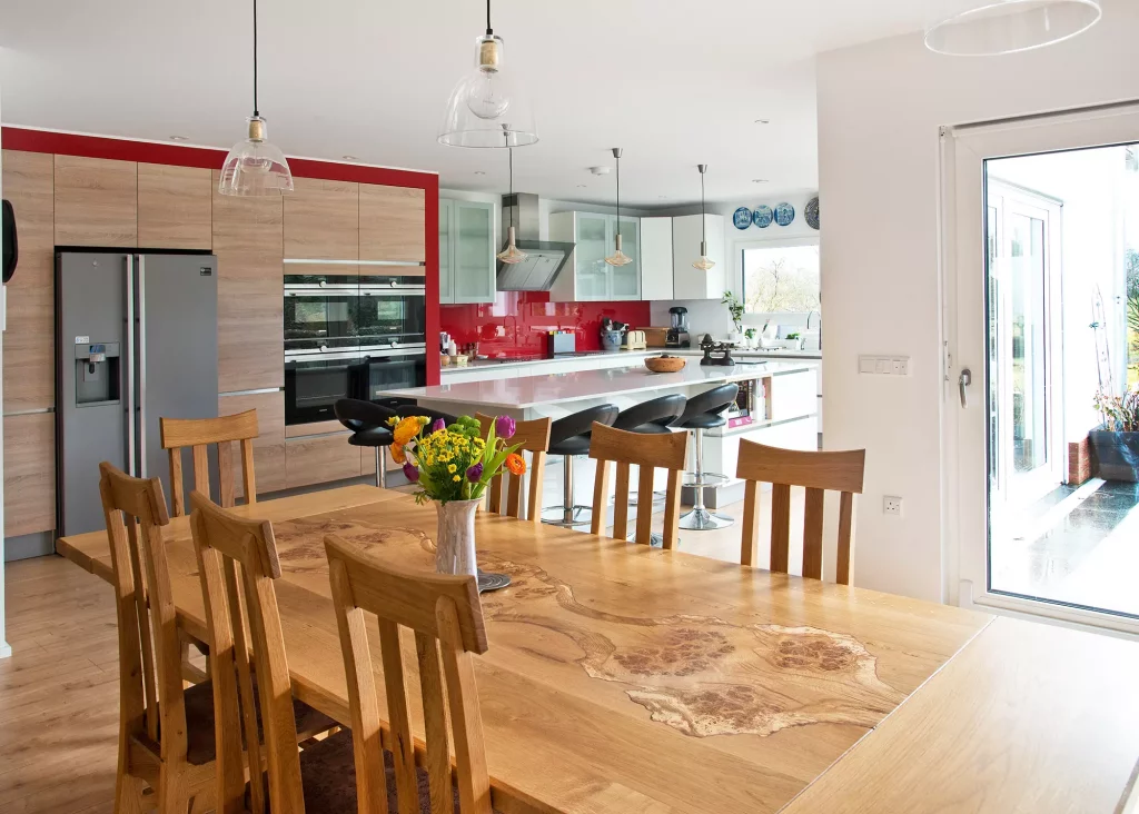 contemporary style kitchen with white counters and red splashback