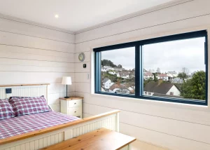 bedroom with white cladding walls with large window