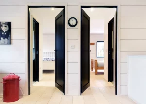 black doors on white walls looking into the log home's bedrooms