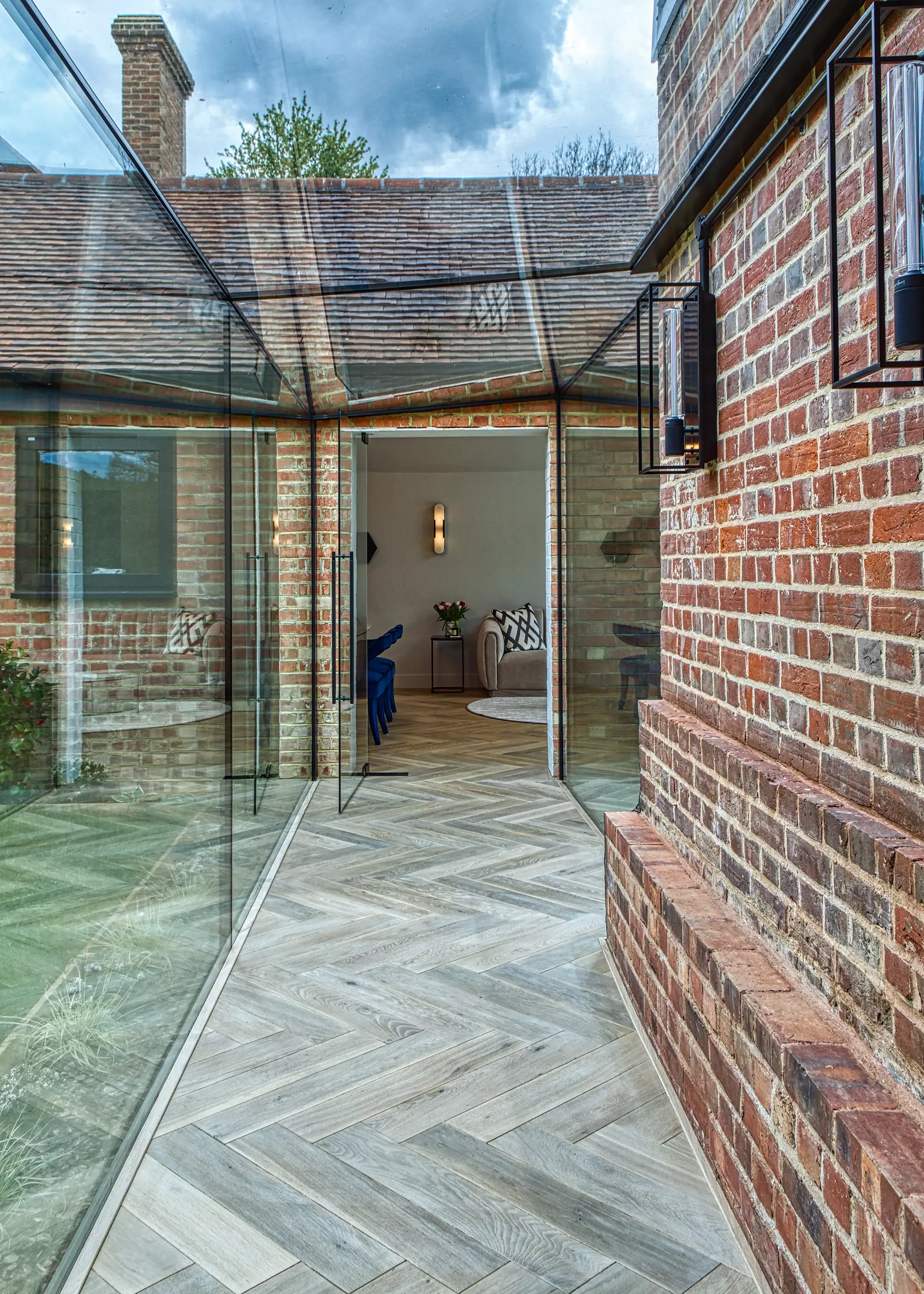 glazed link addition to a red-brick property with herringbone wooden flooring