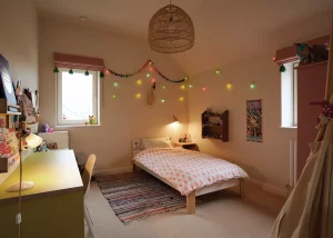 young girl's bedroom with fairy lights and pink accents