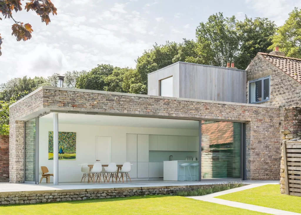 Listed School Building Extension in limstone brick and full-length glazing