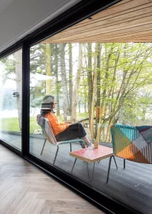 timber frame home with balcony seating area looking out over national park woodland