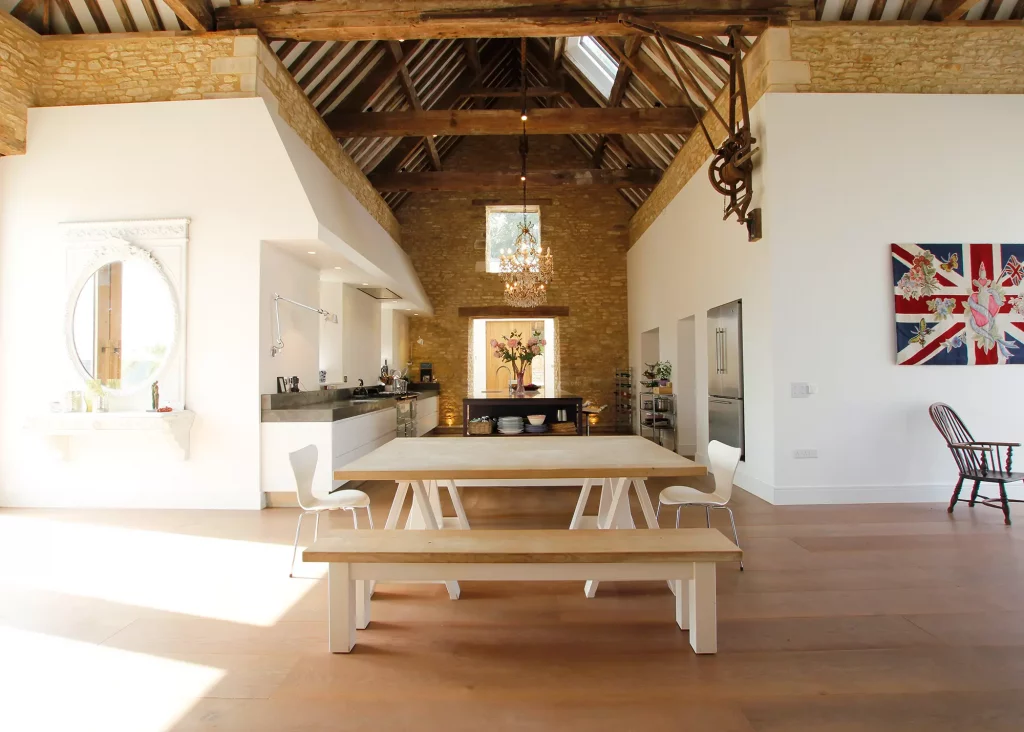 barn conversion with high ceilings and exposed beams and white walls