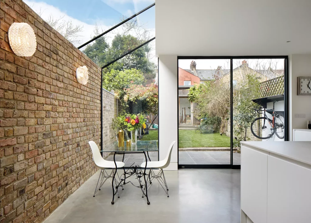 contemporary extension with brick feature wall and frameless glazing