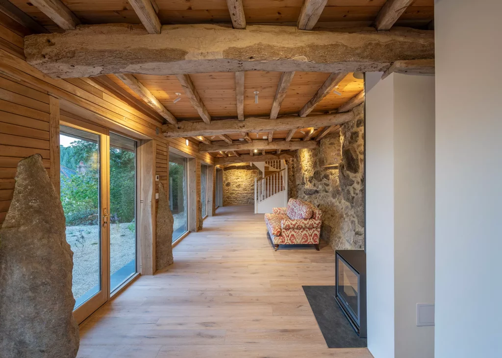 barn conversion interior with exposed stone wall and oak beams