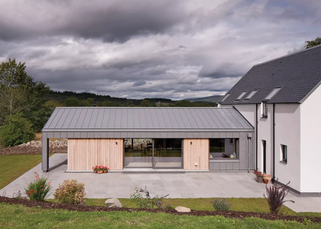 self build home with larch cladding and white render exterior