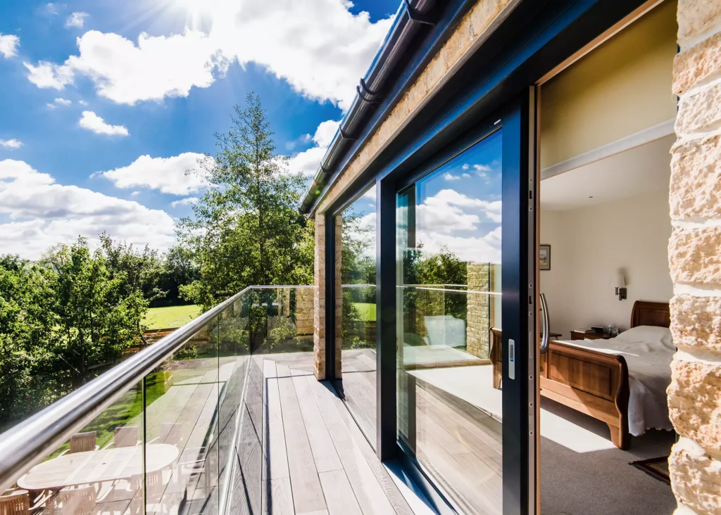 timber frame home with cantilevered balcony and glass balustrades