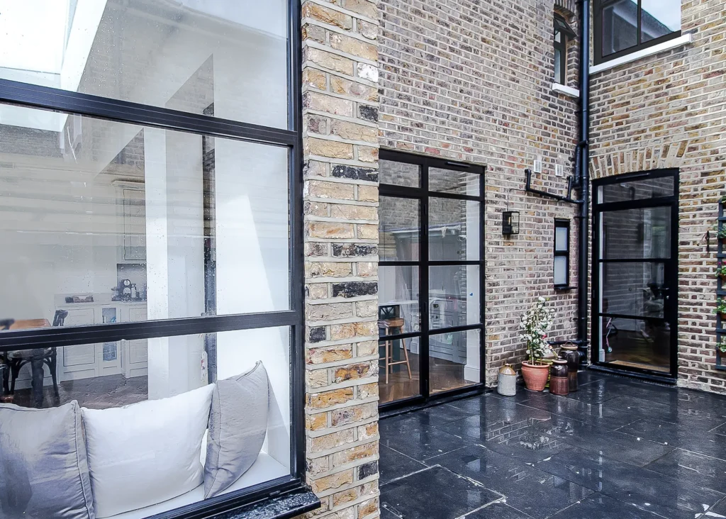 exterior of patio with black framed glazed doors and black patio tiles