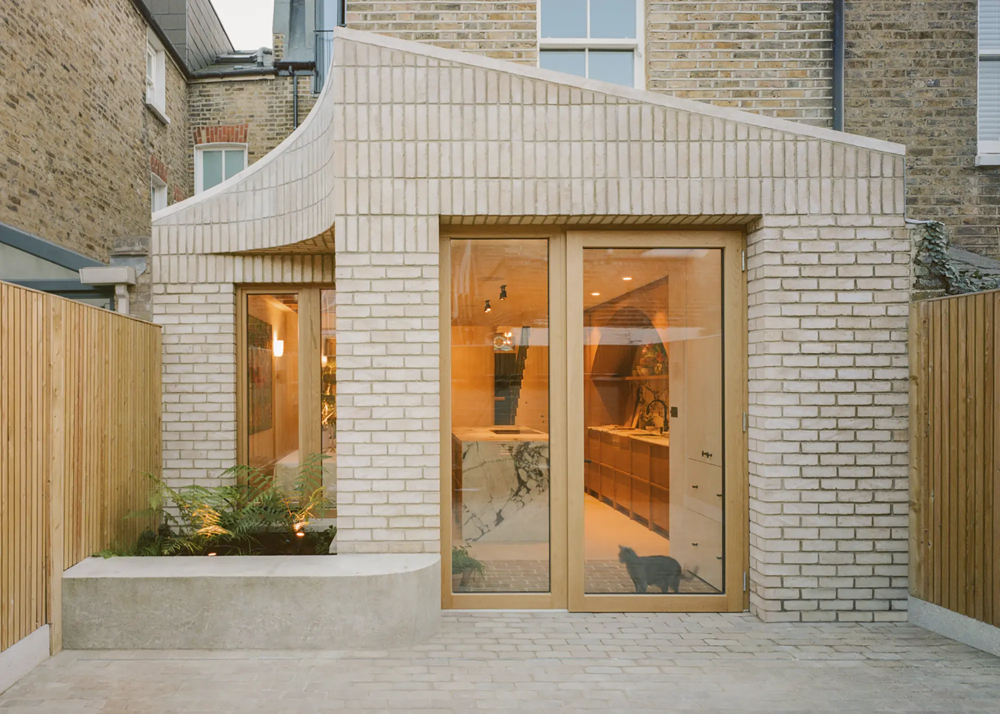 Exciting side extension idea with a curved brick exterior